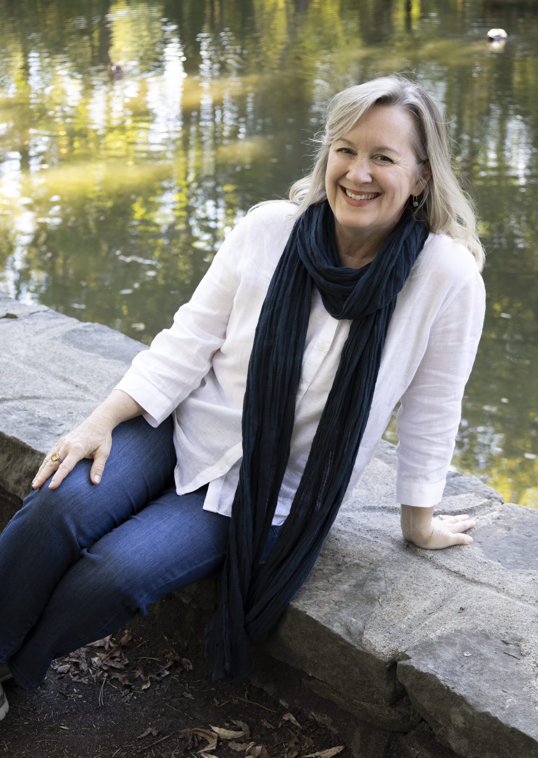 Author sitting beside a pond
